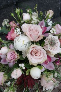 a bouquet of pink and white flowers sitting on top of a table