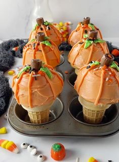 halloween cupcakes with orange frosting and candy in the shape of pumpkins