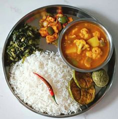 a metal plate topped with rice and veggies