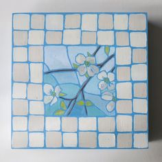 a blue and white tile with flowers painted on it