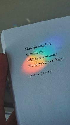 a person holding up a book with the words how strange it is to wake up with eyes searching for someone not here