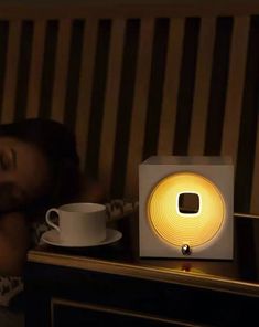 a woman is sleeping next to a coffee cup