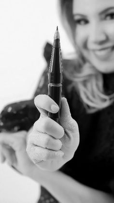 black and white photograph of a woman holding a pen