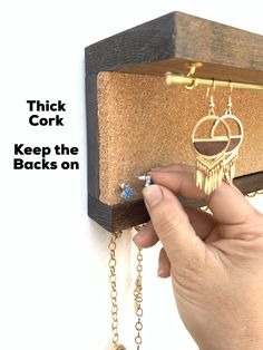 a person holding onto a wooden box with chains hanging from it's sides and the words thick cork keep the backs on