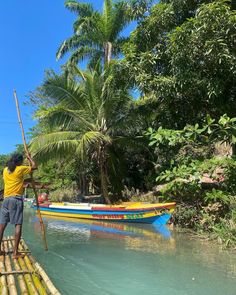 a man standing on top of a wooden raft in the water