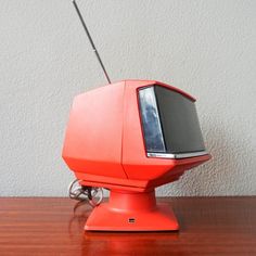 an orange television sitting on top of a wooden table