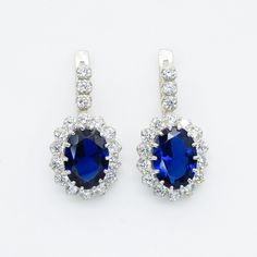 Blue Sapphire Earrings set with a Created Sapphire in a flawless diamond cut & royal blue color, at 14x10mm, 12 Carats a pair. Surrounded with Created CZ Diamonds. Princess Diana Earrings made of Solid 925 Sterling Silver ☞ made to last. Matching Ring: www.etsy.com/listing/254846009 Matching Pendant: www.etsy.com/listing/542319598 D E T A I L S ✓ Adina Stone GIFT BOX provided ♕ GUARANTEE on materials ♕ Hallmark on each piece ✓ Stone: Created Sapphire, 14x10mm, 12 Carats a pair ✓ More Beautiful j Sapphire Halo Design Drop Earrings, Elegant Blue Halo Design Earrings, Blue Halo Design Earrings For Anniversary, Elegant Blue Round Cluster Earrings, Elegant Blue Cluster Earrings As Gift, Elegant Blue Cluster Earrings For Gift, Blue Cubic Zirconia Halo Earrings, Blue Halo Design Earrings As Gift, Blue Fine Jewelry Earrings For Wedding