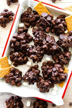 chocolate and marshmallows on a white plate with crackers in the background