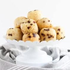 a white bowl filled with cookies sitting on top of a table next to a cloth