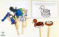 an open book with some stick puppets on top of it next to two ducks and a duckling