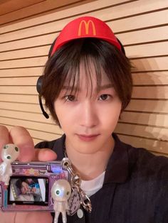 a young man taking a selfie with his cell phone and keychain in front of him