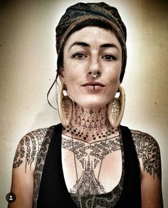 a woman with tattoos and piercings on her chest