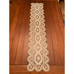 a white doily is sitting on the floor next to a wooden floor with wood planks