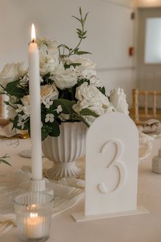 a table with white flowers and candles on it