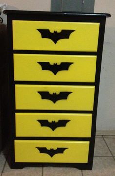 a black and yellow dresser with bats painted on it