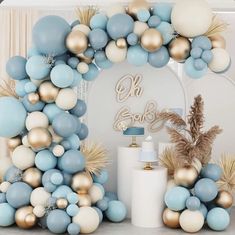 a blue, white and gold balloon arch for a baby shower