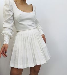 This classic pleated skirt is the epitome of understated elegance, perfect for any occasion that calls for a touch of refined style. With its crisp pleats and minimalist design, it offers a clean, sophisticated look that can be dressed up or down. Available in luxurious natural fabrics like cotton and wool, this skirt not only ensures comfort but also adds a timeless charm to your wardrobe. Whether paired with a tailored blouse or a casual top, this versatile piece is a chic addition to any fash Brown Tennis Skirt, Brown Tennis, Tailored Blouse, Skirt Wool, Mini Skirt Black, Refined Style, Pleated Mini Skirt, Tennis Skirt, Casual Top