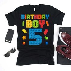 a shirt that says birthday boy 5 with legos on it and some shoes next to it