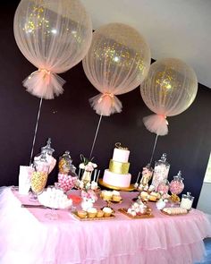 a table topped with lots of cake and balloons