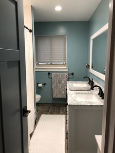 a bathroom with blue walls and white counter tops