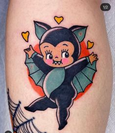 a small tattoo with a bat on it's thigh and hearts in the background