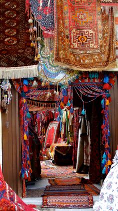 many colorful carpets and rugs are hanging from the ceiling