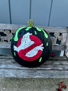 a painted pumpkin sitting on top of a wooden bench