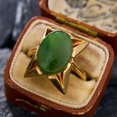 This fantastic retro 1950s ring features a centered oval cabochon cut nephrite jade.  The ring has gorgeous angles and patinated gold work for a simple but bold design.  The ring is crafted in 9k yellow gold and is currently a size 7.25. Retro Green Oval Jewelry, Vintage Oval Jade Rings, Vintage 14k Gold Emerald Oval Cabochon Ring, Vintage 14k Gold Oval Cabochon Emerald Ring, Vintage Jade Rings For Formal Occasions, Vintage Jade Cabochon Ring, Vintage Emerald Cabochon Ring Collectible, Vintage Oval Jade Emerald Ring, Vintage Green Signet Ring With Polished Finish