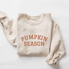 Embroidered Pumpkin Season Sweatshirt. Embroidered with orange thread. Each one is made under eco-friendly, sweatshop-free and ethical working conditions. A sturdy and warm sweatshirt bound to keep you warm in the colder months. A pre-shrunk, classic fit sweater that's made with air-jet spun yarn for a soft feel. This is a unisex sweatshirt, not fitted. Check the size chart for your perfect fit! This product is made especially for you as soon as you place an order, which is why it takes us a bit Fall Cotton Orange Sweater, Orange Cotton Sweatshirt With Relaxed Fit, Orange Relaxed Fit Cotton Sweatshirt, Orange Relaxed Fit Crew Neck Sweater, Orange Long Sleeve Cotton Sweater, Fall T-shirt With Embroidered Logo In Relaxed Fit, Fall Relaxed Fit T-shirt With Embroidered Logo, Relaxed Fit T-shirt With Embroidered Logo For Fall, Fall Cotton T-shirt With Embroidered Graphics