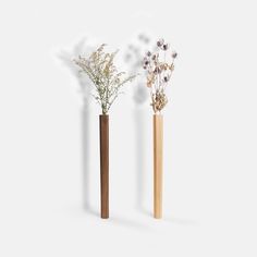 two wooden vases with flowers in them on a white background, one is tall and the other is short