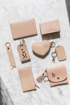 a marble table topped with pink purses and key fobs next to each other