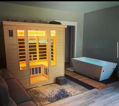 a bathroom with a bathtub and rugs on the floor next to a couch