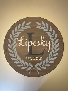 a wooden sign that says lipsky est 2091 with a laurel wreath around it