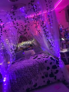 a bed covered in purple lights and curtains