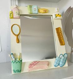 a mirror that is sitting on top of a shelf next to a brush and comb