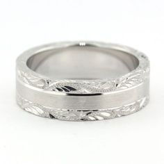 two wedding bands with leaves engraved on the sides, set in white gold or palladium