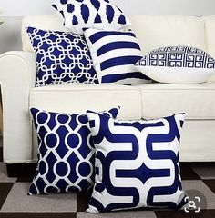 a white couch with blue and white pillows sitting on it's side in front of a black and white checkered floor