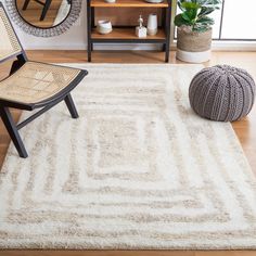 a living room with a chair, mirror and rug