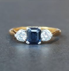 three stone diamond and sapphire ring on grey surface