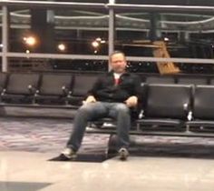 a man sitting on a bench in an airport