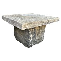 a stone table with a square base on it's side, against a white background