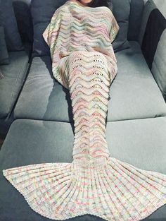 two pictures of mermaid tail knitted blankets on a couch, one is blue and the other is pink