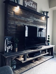 a flat screen tv sitting on top of a wooden entertainment center in a living room