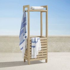 a towel rack sitting on top of a cement floor next to a blue and white towel