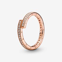 Opt for modern minimalism with the Sparkling Overlapping Ring. This hand-finished, 14k rose gold-plated ring features an asymmetrical design where the square ends of the band slightly overlap to create 90-degree angles. The outer band features clear cubic zirconia pavé framed by micro-beading, the sides have the Pandora logo and the inner shank has cut-out hearts. There are two Pandora Crown O monograms at the end of each profile. Subtly stunning on its own or show-stopping when multiple are sta Rose Gold Stackable Rings, Pandora Logo, Pandora Rose Gold, Pandora Rose, Rose Gold Plated Ring, Bracelet Pandora, Pandora Rings, Pandora Jewelry, Silver Roses