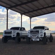 two large trucks parked under a covered structure