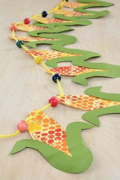 a long row of paper fish made to look like corn on the cob with beads