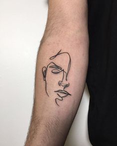 a man's arm with a black and white line drawing of a face on it