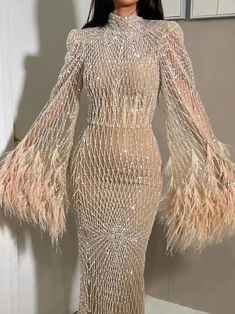 A model wearing the nude feather evening gown, showcasing its elegant silhouette and flowing train. Golden Atelier 8 Nude Evening Dresses, Gown With Long Sleeves, Arabic Wedding, Dresses Long Sleeves, Arab Wedding, Long Sleeve Dress Formal, Flare Long Sleeve, Mob Dresses, Long Sleeve Evening Dresses