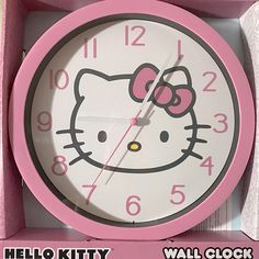 a hello kitty wall clock in a pink box with the word hello kitty on it